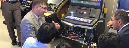 Commissioner Enrique Zuniga, Gaming Technical Compliance Manager Scott Helwig show members of the Resourceful Center for Japanese Gambling the MGC Gaming Lab